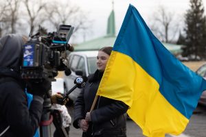 woman in black jacket holding ukraine flag